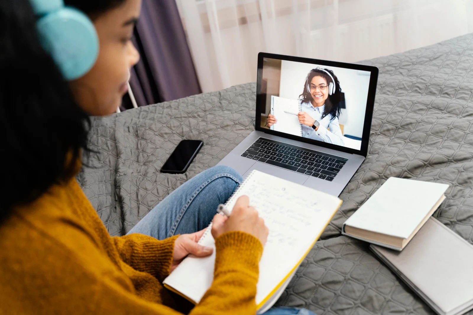 Aluna fazendo anotações durante uma aula de inglês online de casa