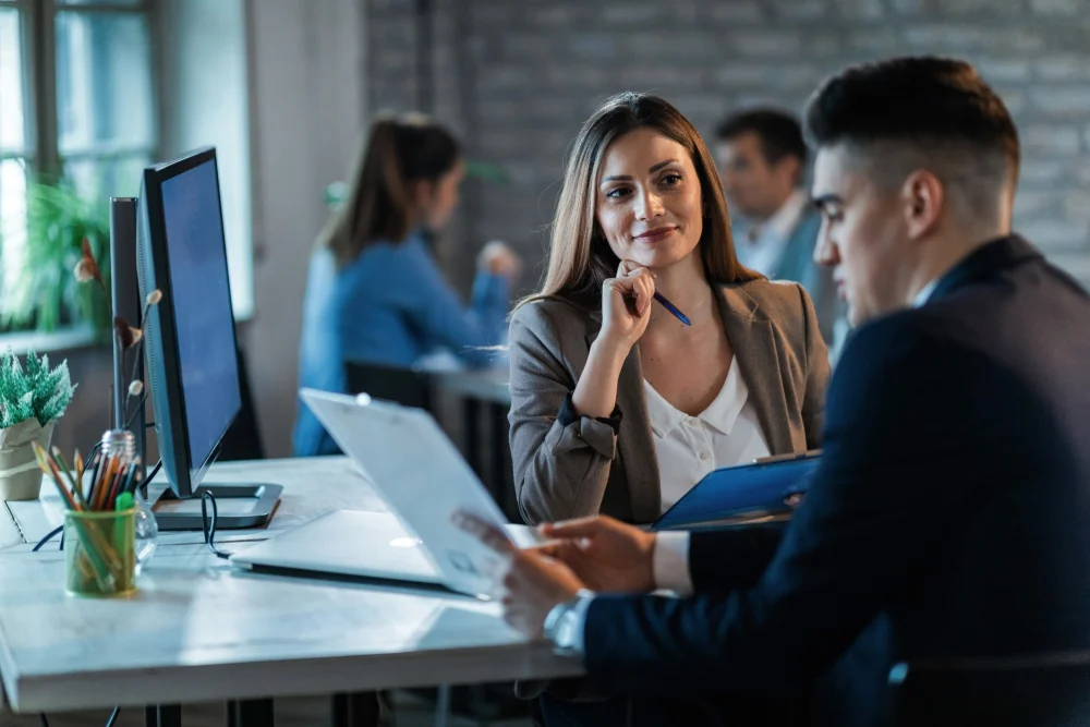 Profissionais em reunião de trabalho praticando inglês para negócios (Business English) no escritório