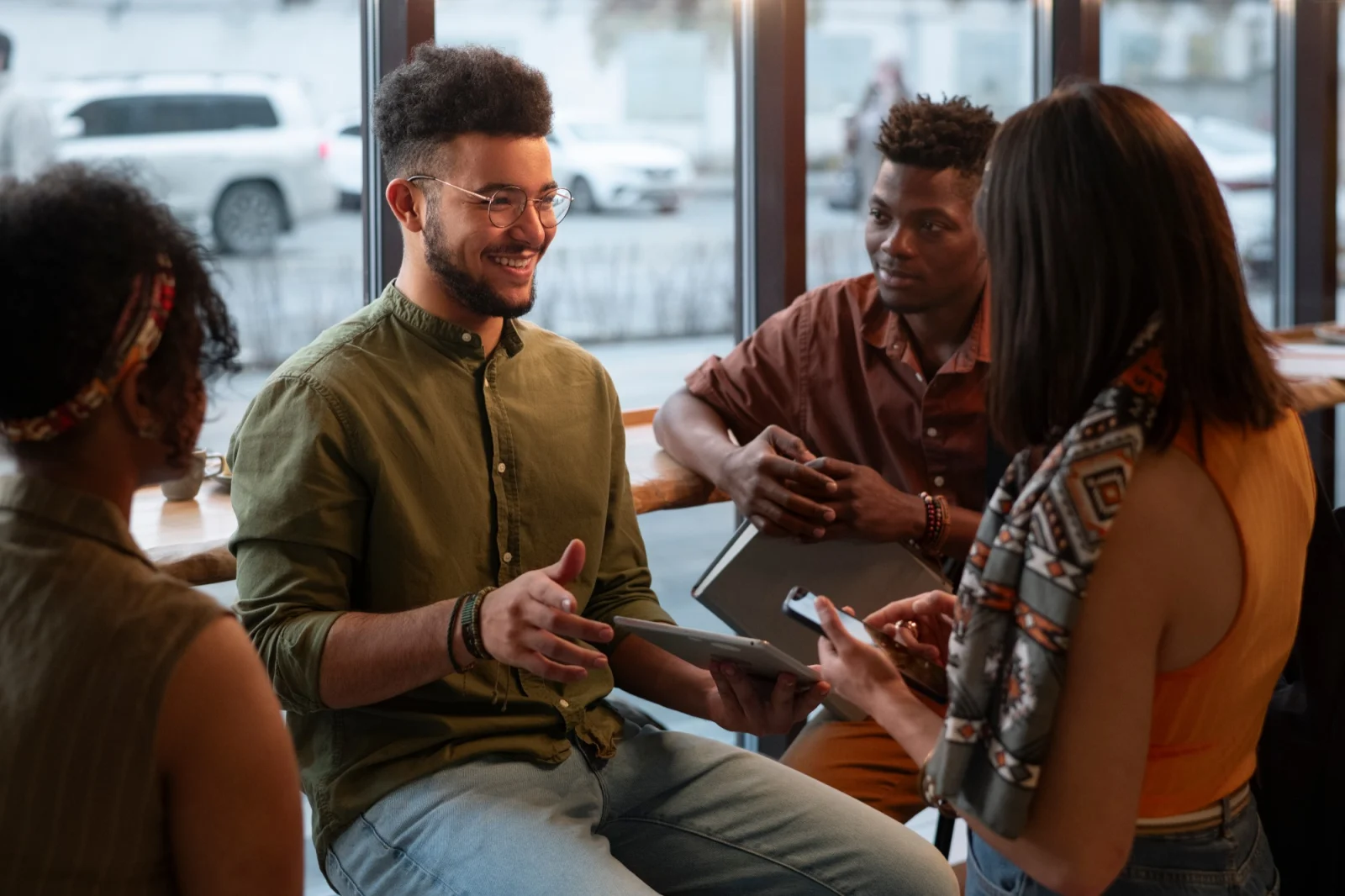 Alunos conversando em inglês em grupo, trocando ideias em uma mesa