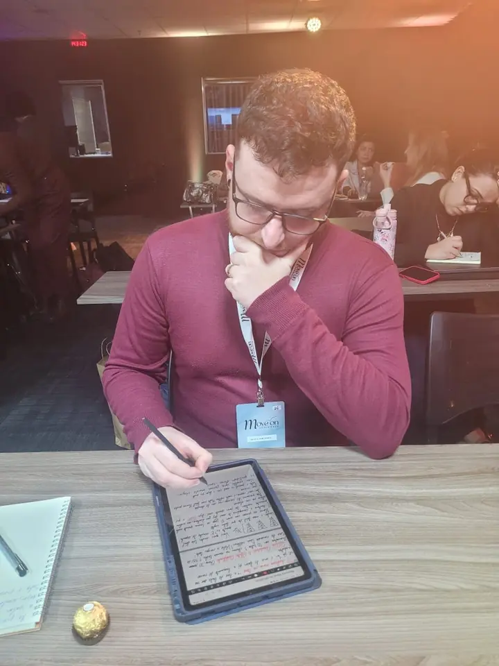 Guilherme Carvalho, professor da Florescer Idiomas, fazendo anotações em um tablet
