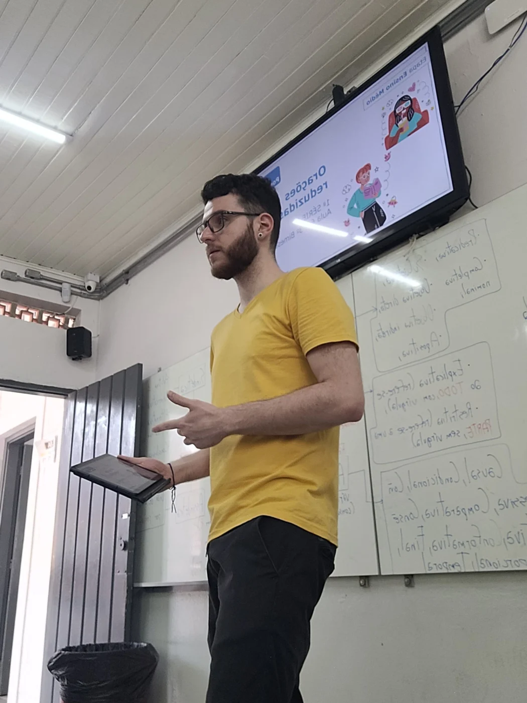 Professor Guilherme Carvalho conduzindo uma aula com um tablet na mão