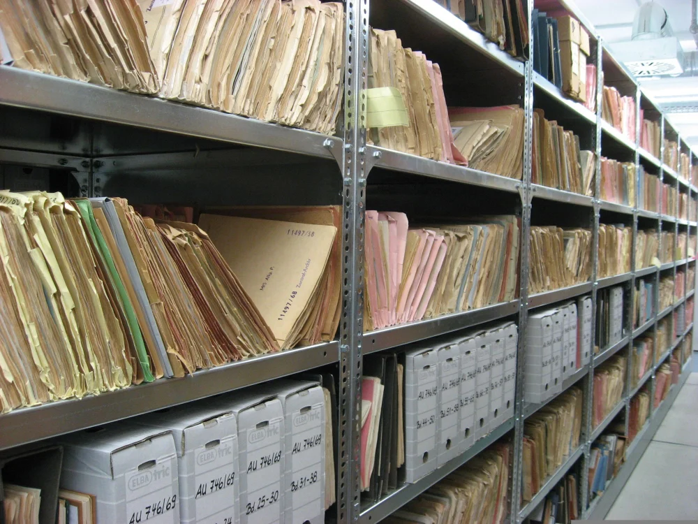 Prateleiras com pastas e documentos organizados, rotina administrativa de quem usa inglês para gestão