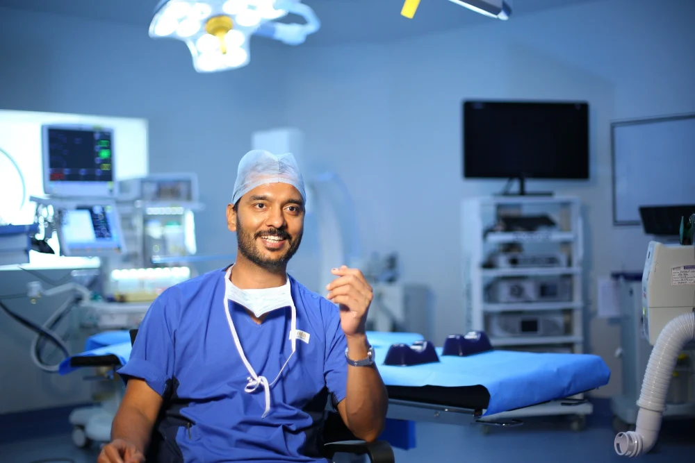 Médico sorrindo em um centro cirúrgico, profissional que desenvolve inglês para médicos