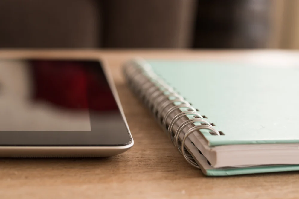 Tablet e caderno sobre a mesa, rotina de estudo de inglês para RH