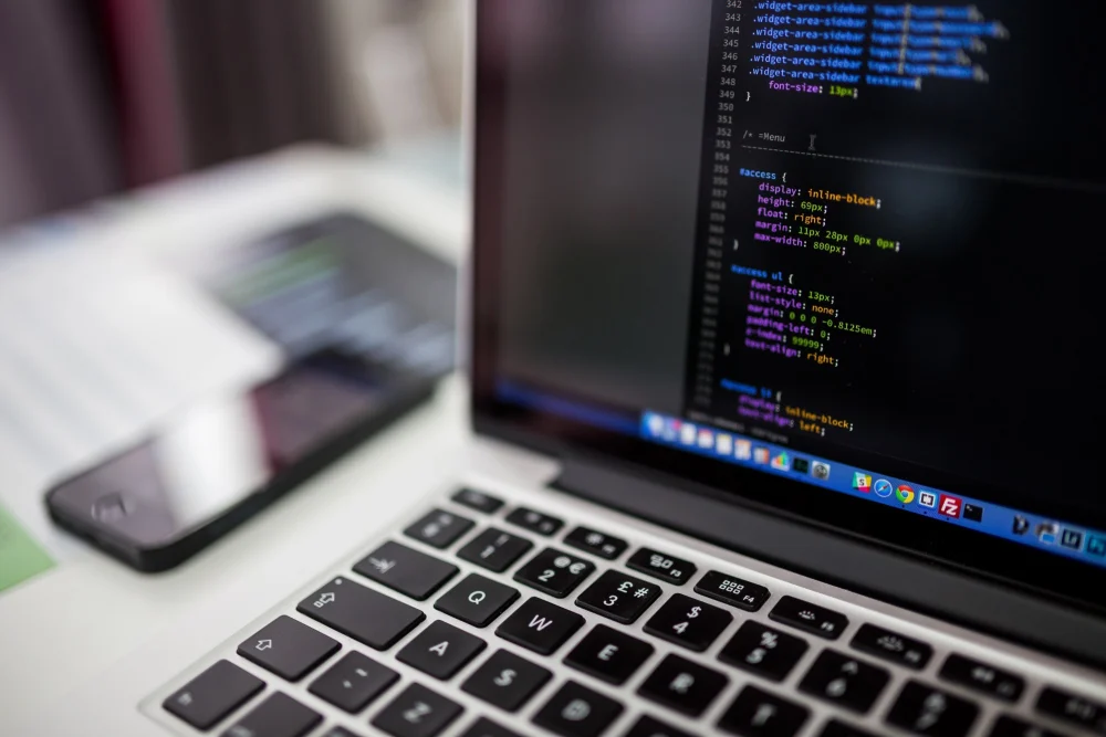 Código na tela do notebook, rotina de profissionais de tecnologia que usam inglês para TI